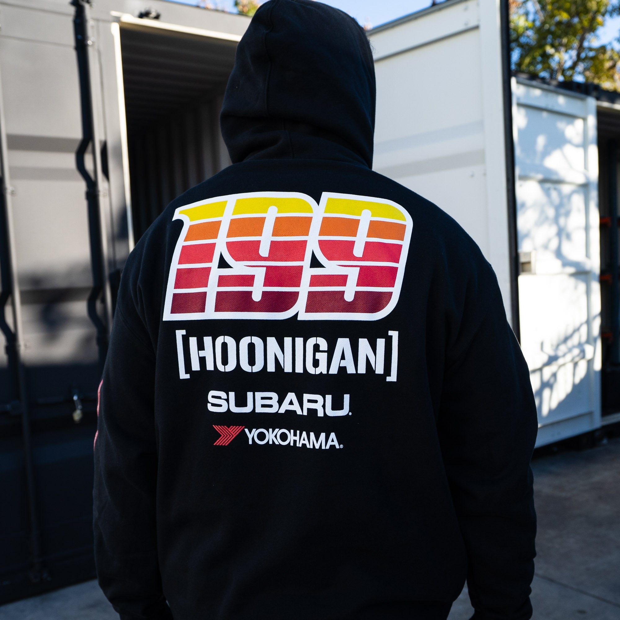 Black pullover hoodie featuring a retro-style graphic with "199" and "Hoonigan Subaru Yokohama" on the back.