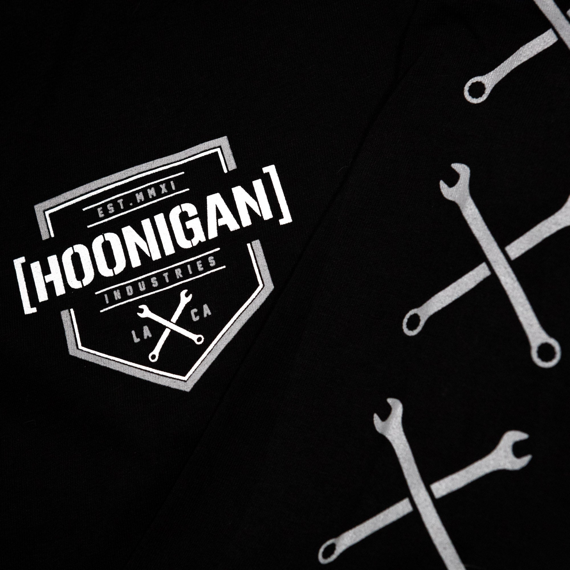 Black long sleeve t-shirt featuring Hoonigan logo and crossed wrench graphics, perfect for motorsport enthusiasts.