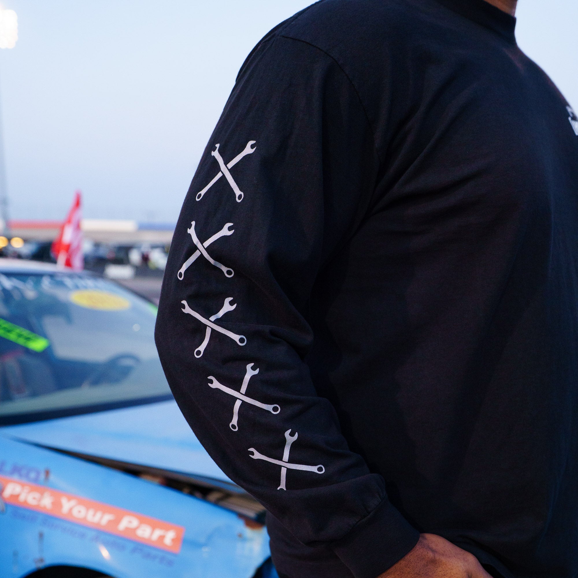 Black long sleeve t-shirt featuring Hoonigan logo and crossed wrench design on the sleeves, perfect for car enthusiasts.