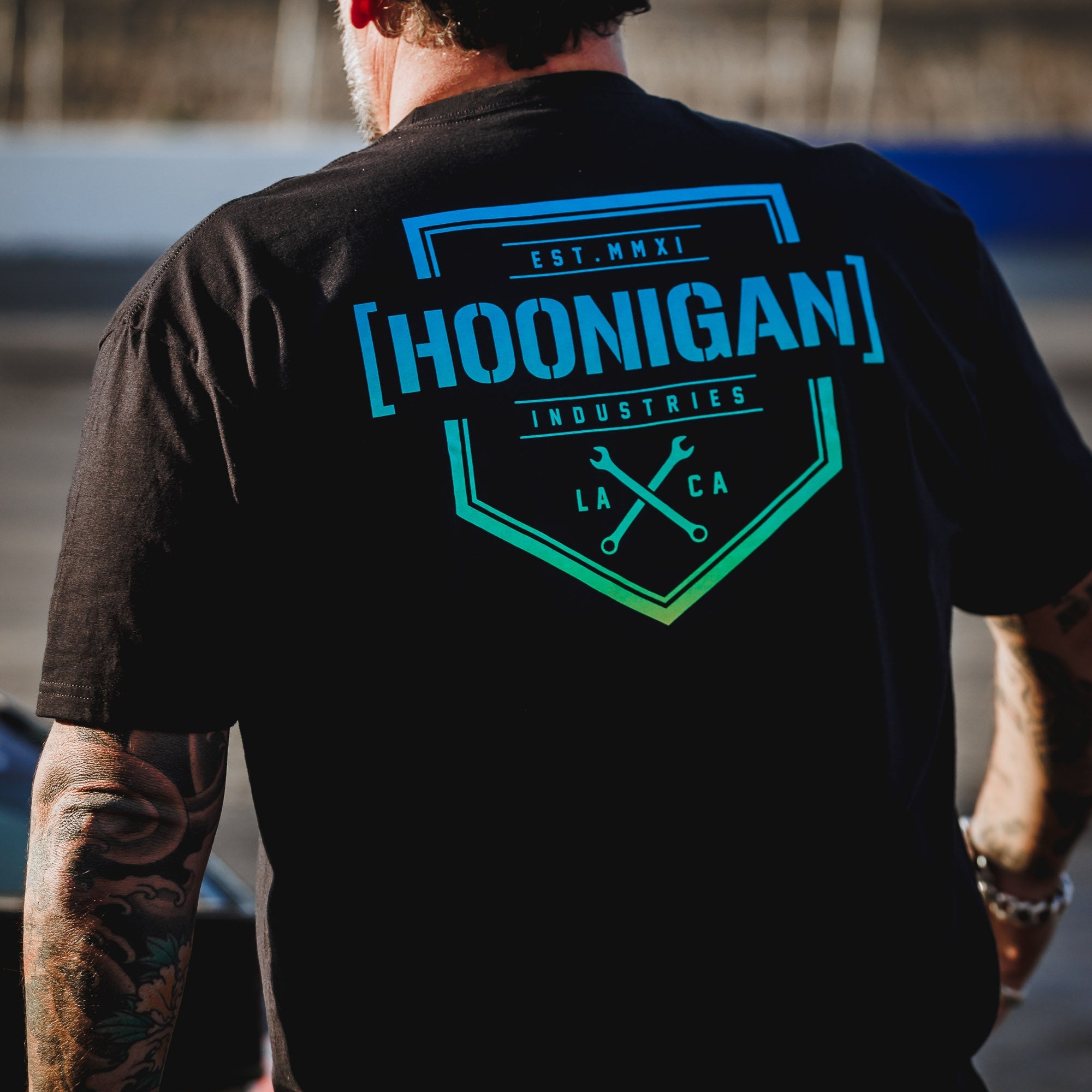 Black short sleeve t-shirt featuring the Hoonigan logo and graphic design, ideal for motorsport enthusiasts.