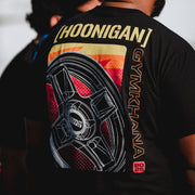 Black short sleeve t-shirt featuring a colorful graphic of a wheel and the text "Hoonigan GYMKHANA" on the back.