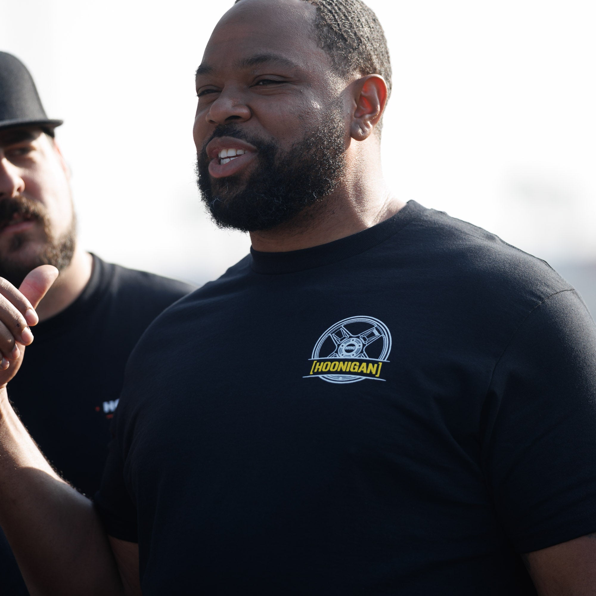 Man wearing a black Hoonigan GYMKHANA AUSSIE SHRED HKR short sleeve t-shirt, showcasing automotive lifestyle and culture.
