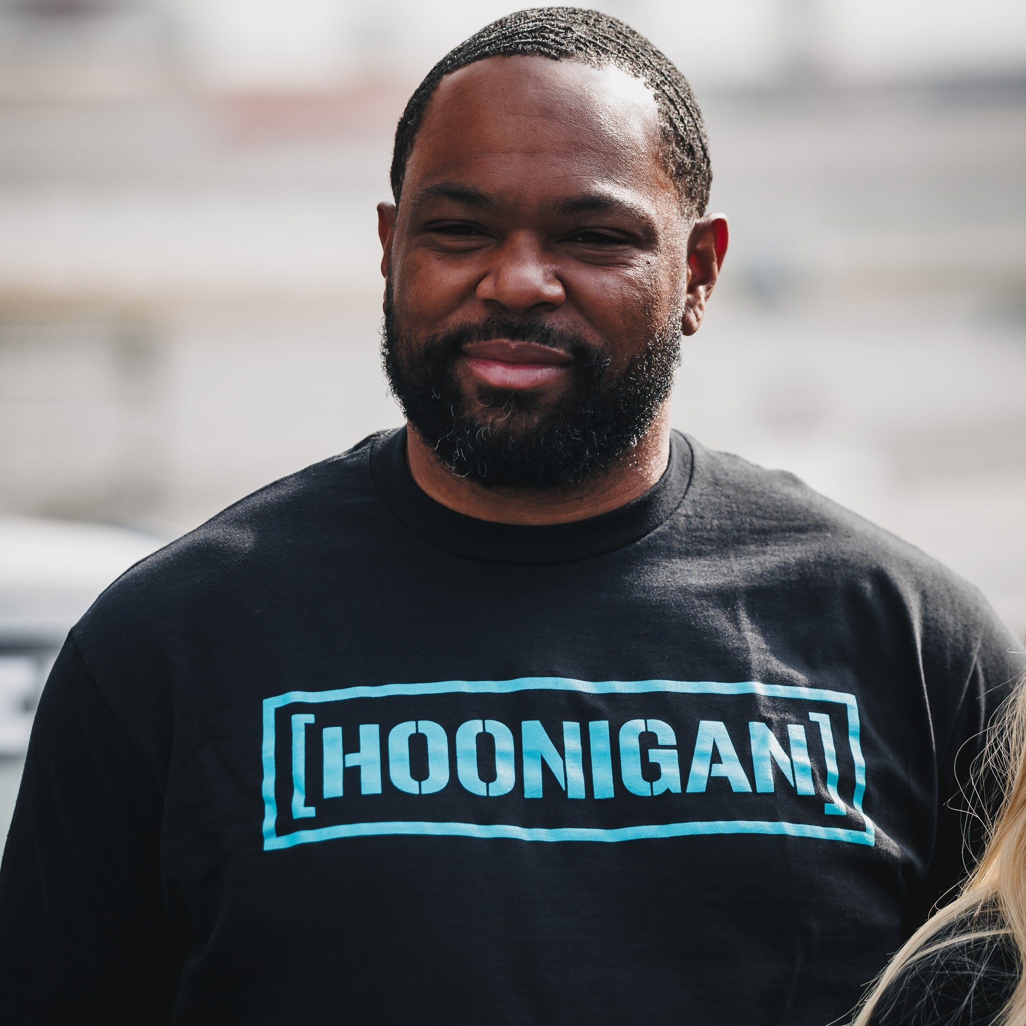 A person wearing a black Hoonigan CENSOR BAR short sleeve t-shirt stands outdoors, showcasing the bold logo design.