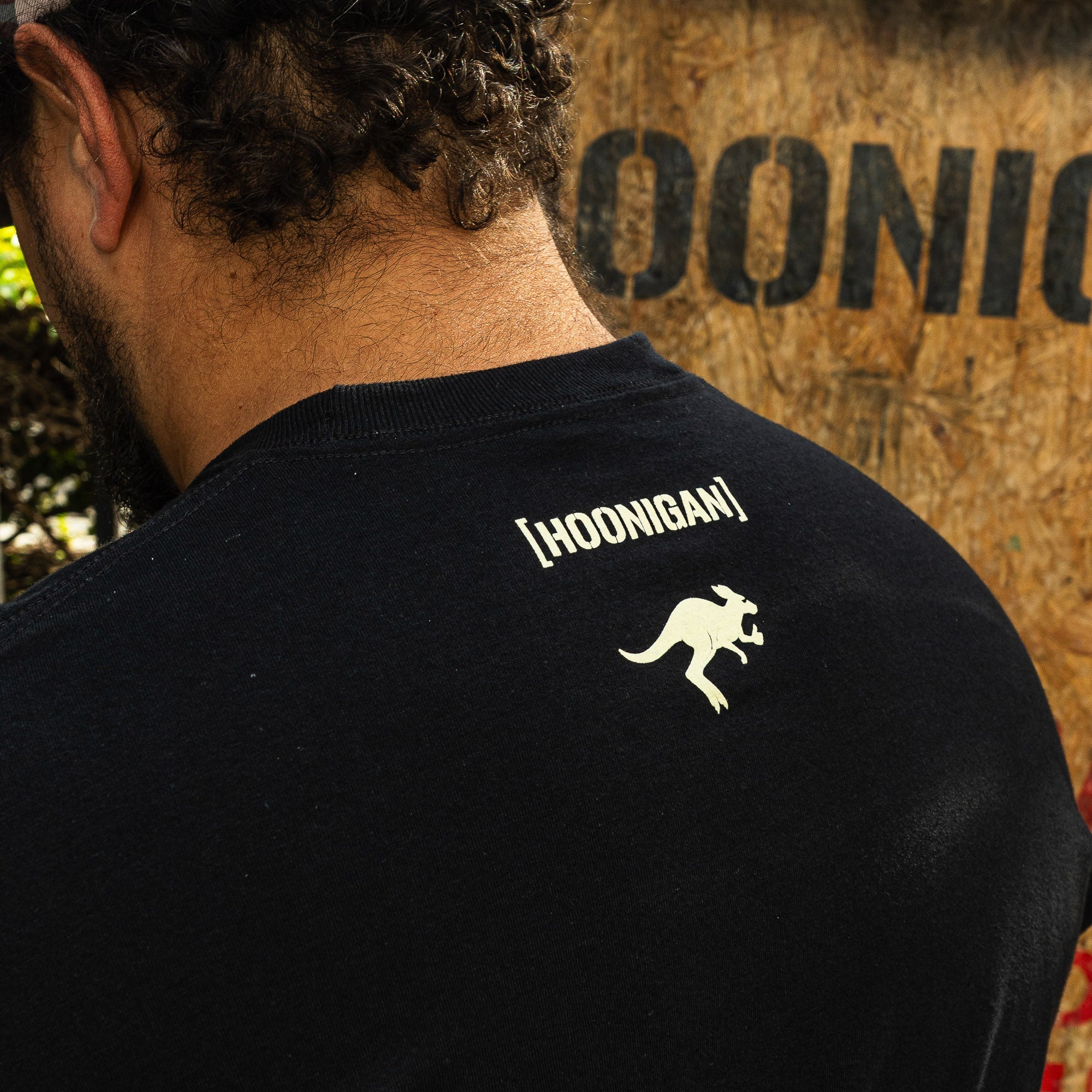 Black short sleeve t-shirt featuring a kangaroo graphic and Hoonigan logo on the back, ideal for motorsport enthusiasts.