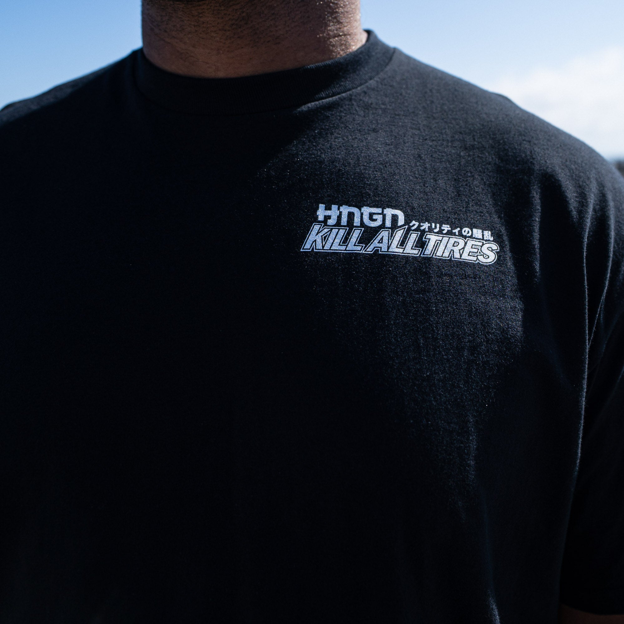 Black short sleeve tee featuring Hoonigan logo and "KILL ALL TIRES" text, perfect for motorsport enthusiasts.