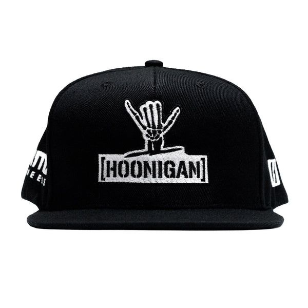 Black snapback hat featuring the Hoonigan logo and Shreddy graphic, perfect for motorsport enthusiasts and car culture fans.