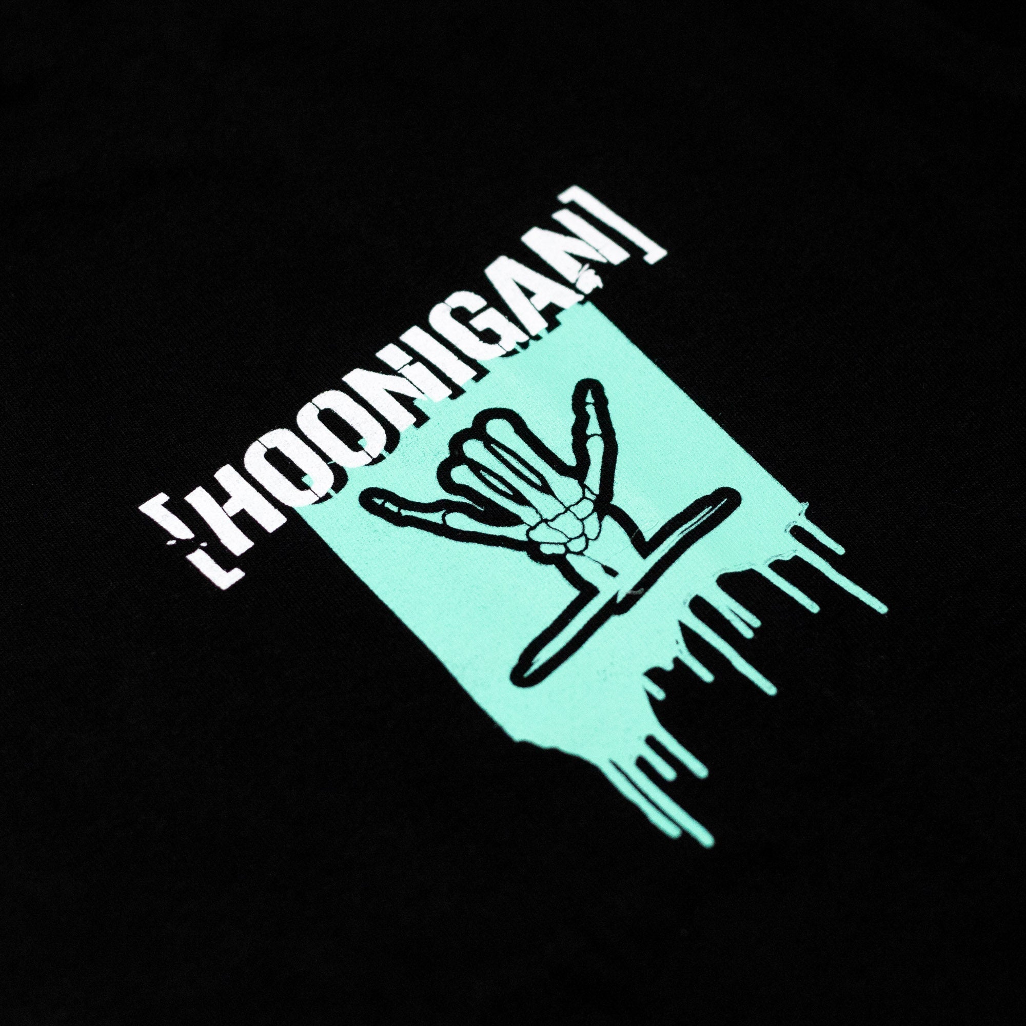 Black short sleeve t-shirt featuring Hoonigan logo and Shreddy graphic with a dripping design in mint green.