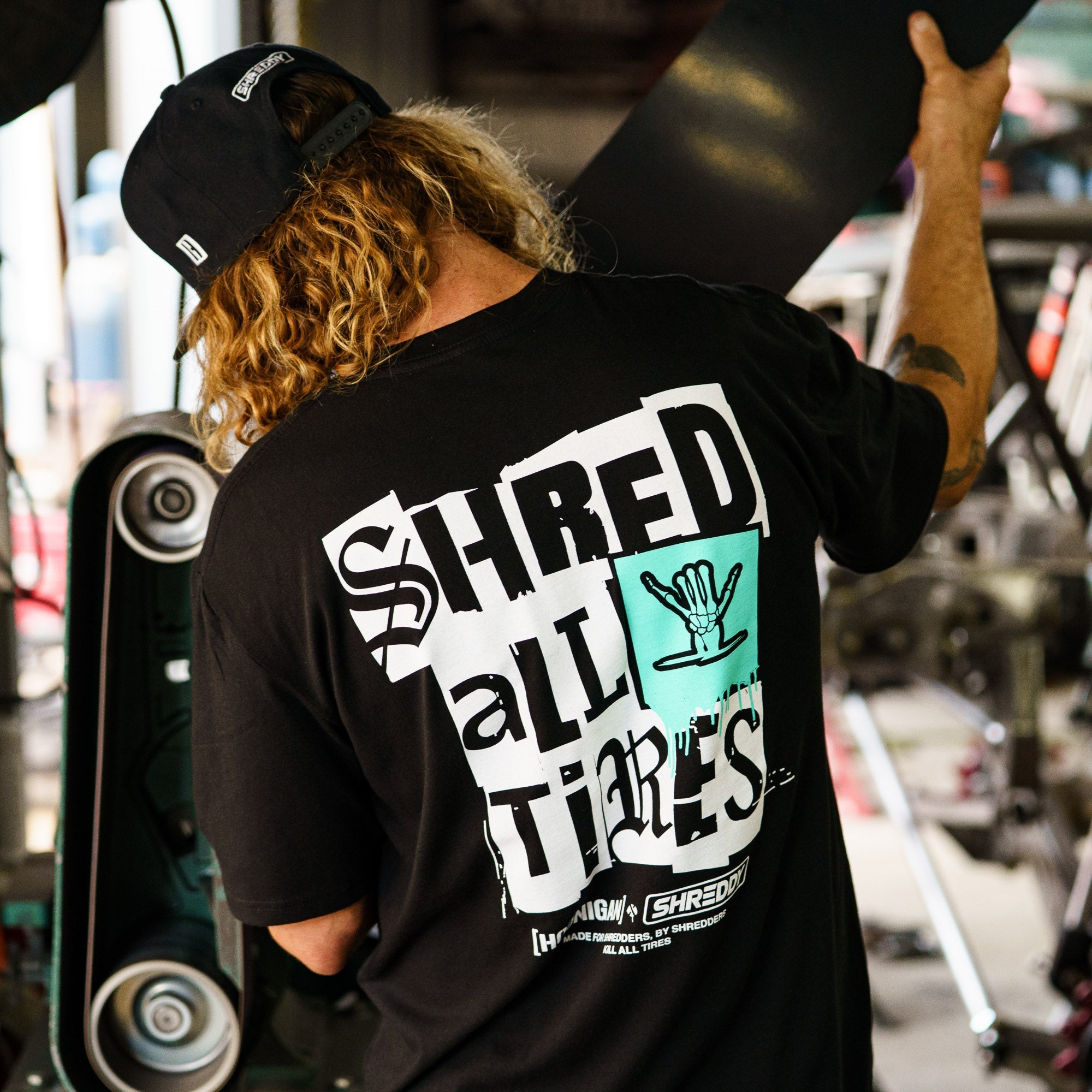 Black short sleeve t-shirt featuring "SHRED ALL TIRES" graphic, perfect for motorsport enthusiasts and car culture fans.