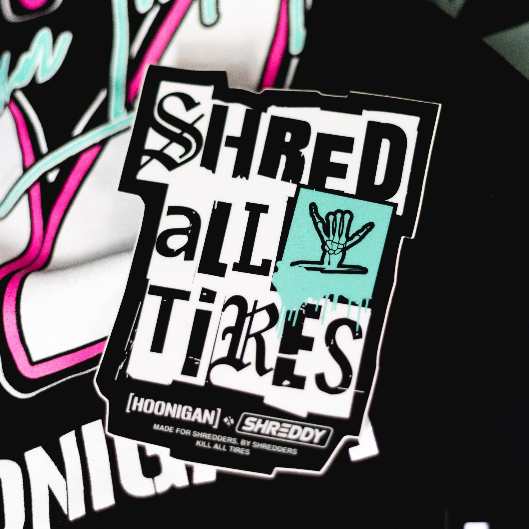 Hoonigan x Shreddy SHRED ALL TIRES sticker featuring bold text and a hand graphic, perfect for motorsport enthusiasts.