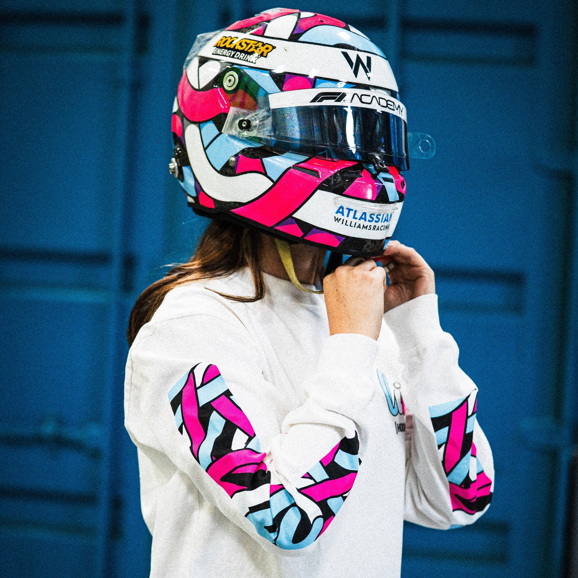 Hoonigan x Lia Block SCRIPT Long Sleeve T-Shirt worn by a person adjusting a colorful racing helmet, showcasing bold designs.