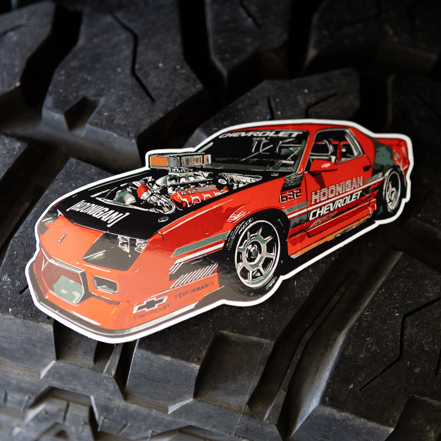 Hoonigan 632 sticker featuring a detailed illustration of a red Chevrolet car with a powerful engine design.