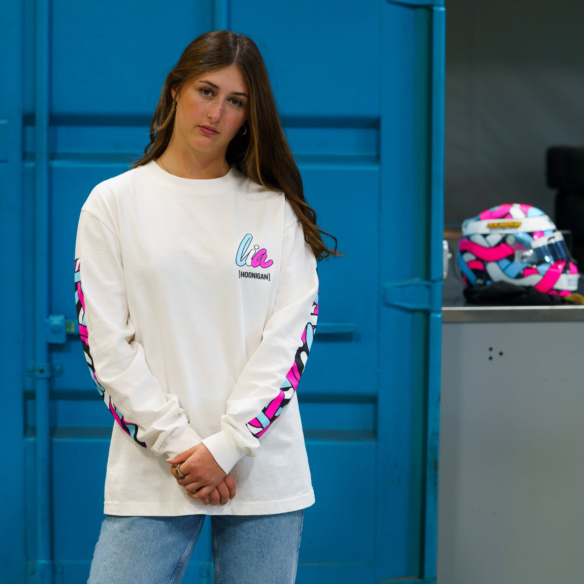 Model wearing Hoonigan x Lia Block SCRIPT Long Sleeve T-Shirt, featuring bold graphics and a stylish design in a garage setting.